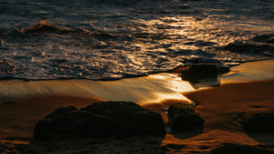 sanfte Wellen spülen an den Strand im goldenen Licht