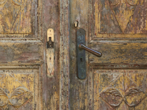 alte Holztür mit Patina ist verschlossen. Sie symbolisiert die Vergangenheit.
