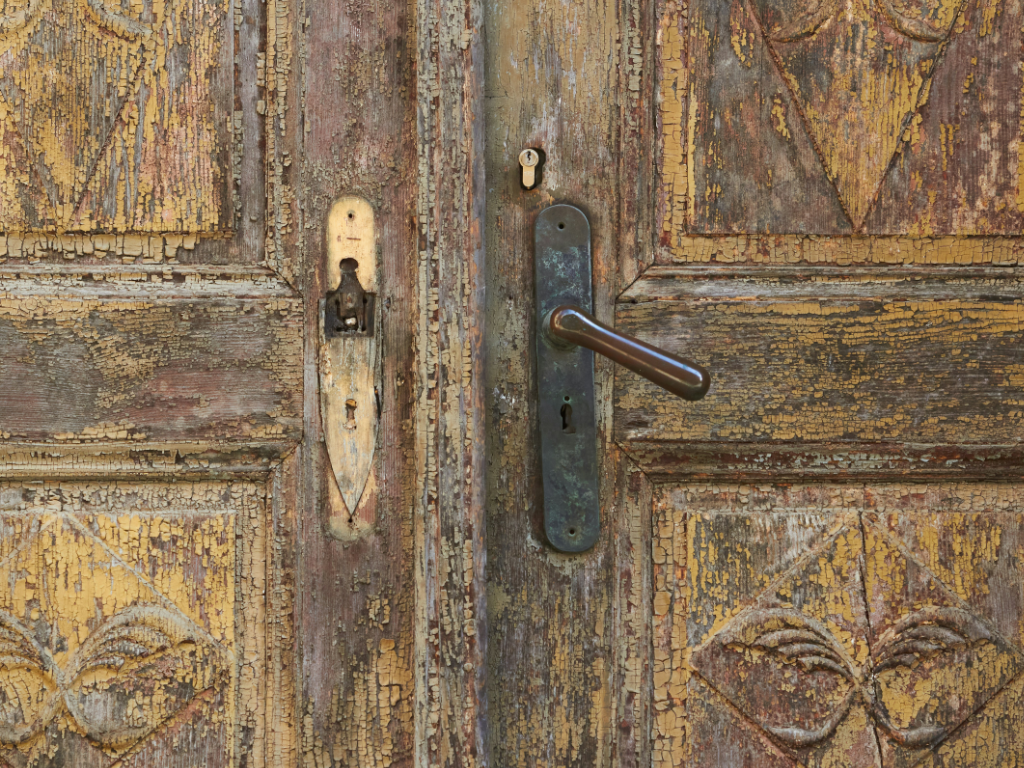 alte Holztür mit Patina ist verschlossen. Sie symbolisiert die Vergangenheit.